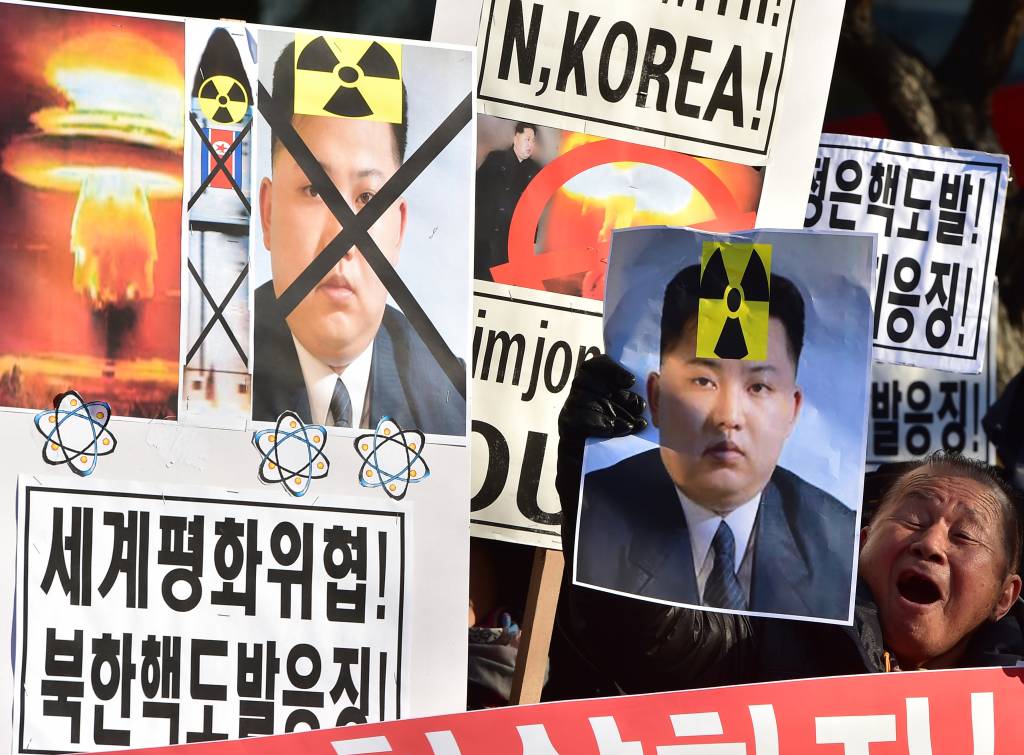Ativistas sul-coreanos gritam slogans com cartazes mostrando retratos do l&iacute;der norte-coreano Kim Jong-Un durante uma manifesta&ccedil;&atilde;o denunciando o teste da bomba de hidrog&ecirc;nio da Coreia do Norte, em Seul em 7 de janeiro de 2016.