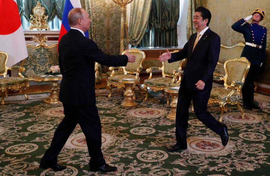 O presidente russo Vladimir Putin recebe o ex primeiro-ministro japonês Shinzo Abe no Kremlin em Moscou, 26/05/2018.