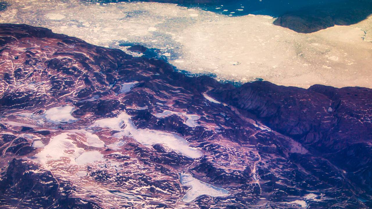 Vsta aérea de geleiras de derretimento na Groenlândia com gelo e neve no verão