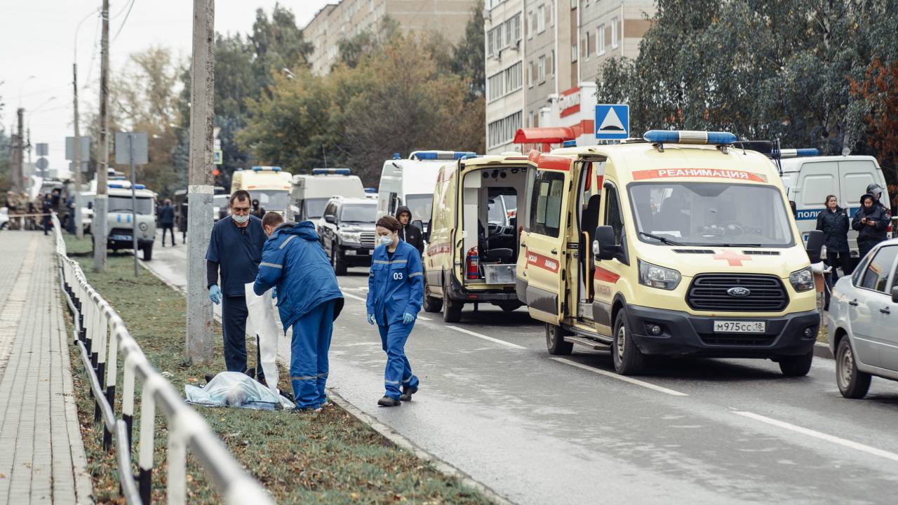 Medics gather at the body of a dead person near the scene of a shooting in school No88 in Izhevsk on September 26, 2022. - The death toll has risen to 13 people, including seven children, after a man opened fire on September 26 at his former school in central Russia, authorities said. (Photo by Maria BAKLANOVA / Kommersant Photo / AFP) / Russia OUT