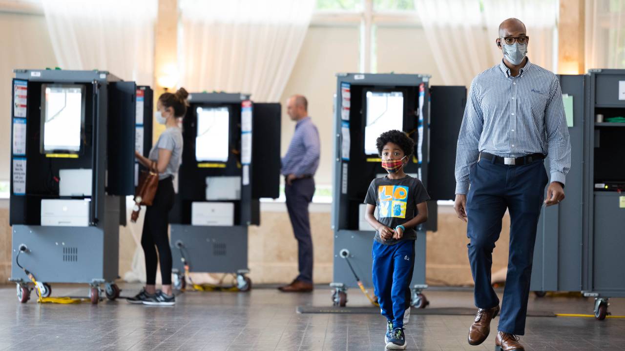 ATLANTA, GA - 24 DE MAIO: Um eleitor e seu filho deixam o local de votação do Park Tavern depois de votar nas eleições primárias da Geórgia em 24 de maio de 2022 em Atlanta, Geórgia. Os eleitores de toda a Geórgia votarão em vários cargos, incluindo assentos no Senado dos EUA, secretário de Estado da Geórgia e o cargo de governador.