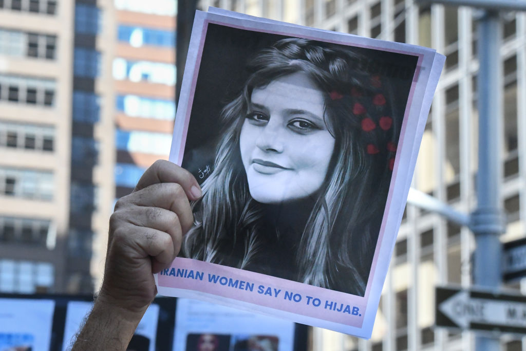 NEW YORK, NY - SEPTEMBER 21: People hold up a photo of Iranian woman Mahsa Amini as they participate in a protest against Iranian President Ebrahim Raisi outside of the United Nations on September 21, 2022 in New York City. Protests have broke out over the death of 22-year-old Iranian woman Mahsa Amini, who died in police custody for allegedly violating the country's hijab rules. Amini's death has sparked protests across Iran and other countries. (Photo by Stephanie Keith/Getty Images)