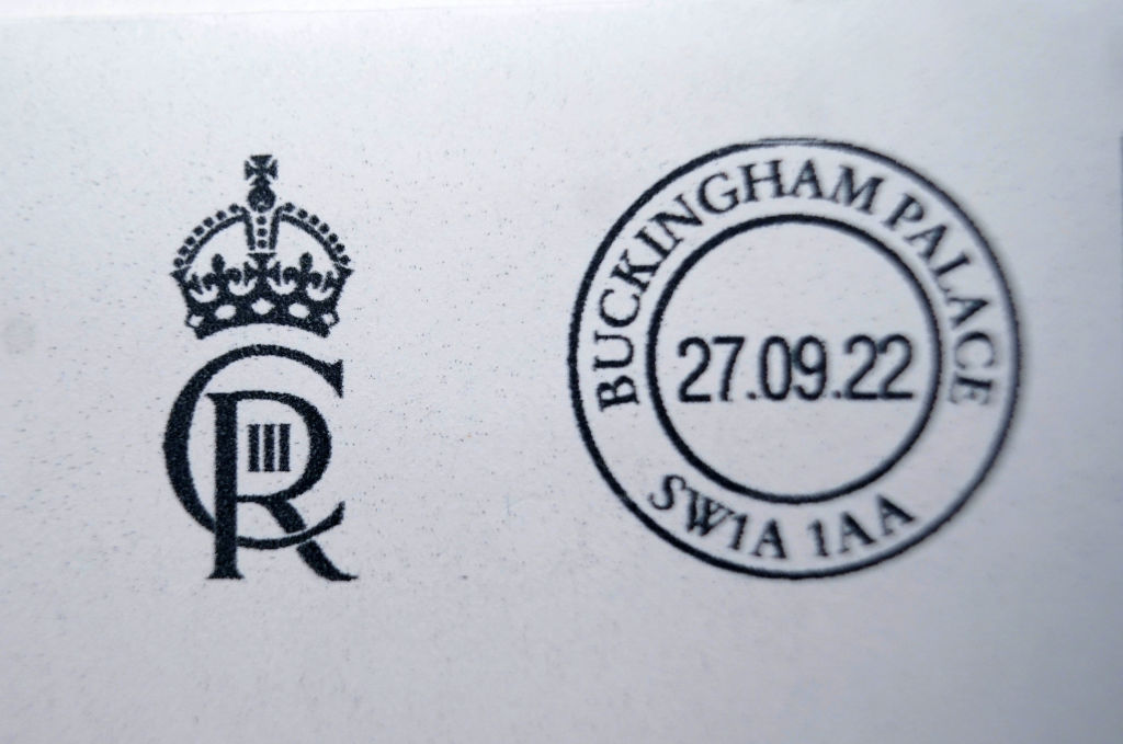 First Items Of Mail Franked With The King’s New Cypher LONDON, ENGLAND - SEPTEMBER 27: A detailed view of a letter franked with the new cypher of King Charles III at the Court Post Office at Buckingham Palace on September 27, 2022 in London, England. The King Charles III's cypher is a monogram consisting of the initials of monarch's name and latin title; CR. The design was chosen by the monarch from a series put together by The College of Arms and will be used to frank all mail leaving Buckingham Palace. (Photo by Yui Mok - Pool/Getty Images)
