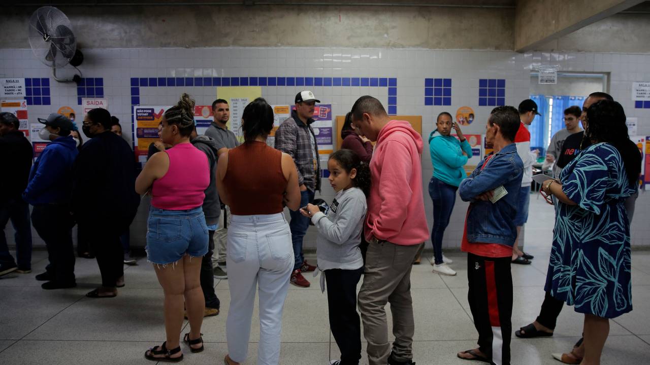 People queue to vote during the legislative and presidential election, in Sao Paulo, Brazil, on October 2, 2022. - Voting began early Sunday in South America's biggest economy, plagued by gaping inequalities and violence, where voters ar expected to choose between far-right incumbent Jair Bolsonaro and leftist front-runner Luiz Inacio Lula da Silva, any of which must garner 50 percent of valid votes, plus one, to win in the first round. (Photo by CAIO GUATELLI / AFP)