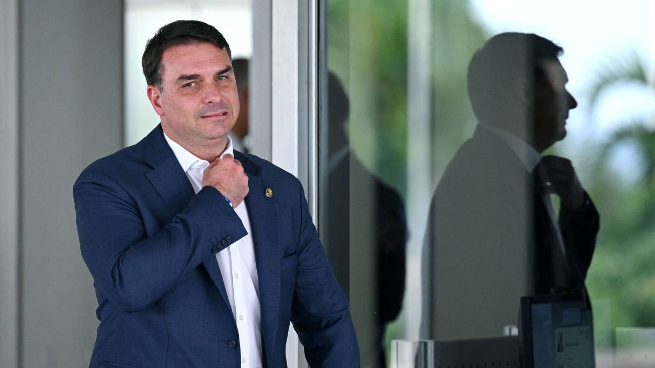 Brazilian Senator Flavio Bolasonaro, son of President Jair Bolsonaro, gestures as he leaves Planalto Palace in Brasilia, on October 4, 2022. - Brazil's bitterly divisive presidential election will be decided in a runoff on October 30 as incumbent Jair Bolsonaro beat first-round expectations to finish a closer-than-expected second to front-runner Luiz Inacio Lula da Silva in the October 2 first round. (Photo by EVARISTO SA / AFP)