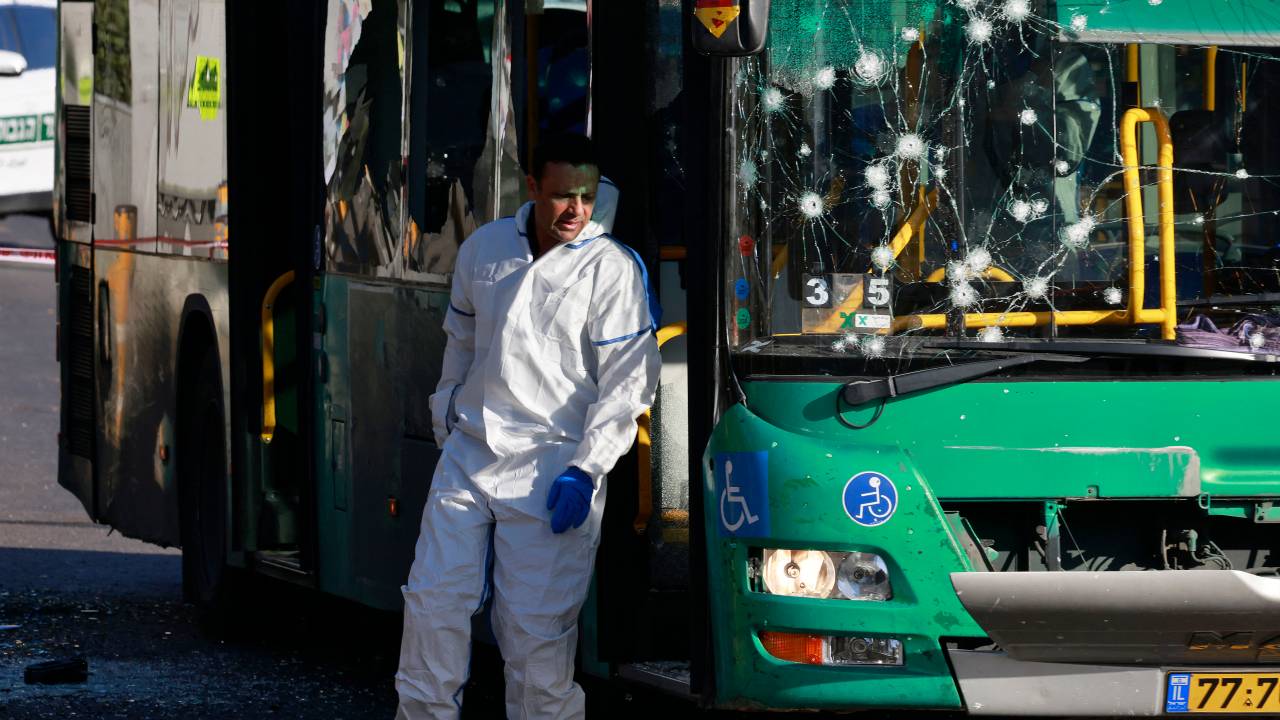 Israeli forensic experts collect evidence at the scene of an explosion at a bus stop in Jerusalem on November 23, 2022. - At least one person was killed and 15 other wounded in two separate explosions targeting bus stations in Jerusalem, security and medical officials said, with Israel's public security minister calling them "attacks." (Photo by Menahem KAHANA / AFP)