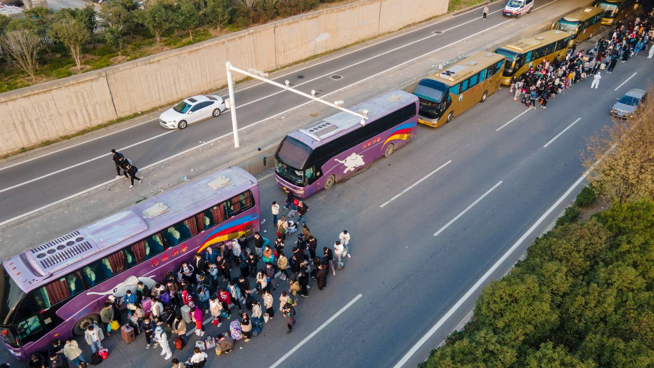 ZHENGZHOU, CHINA - 30 DE OUTUBRO: Os funcionários da Foxconn pegam ônibus para voltar para casa em 30 de outubro de 2022 em Zhengzhou, província de Henan, na China. Ônibus de transporte foram organizados pelas autoridades locais para facilitar as viagens de volta dos trabalhadores da fábrica da Foxconn para suas cidades natais depois que as infecções por COVID-19 foram relatadas na cidade de Zhengzhou