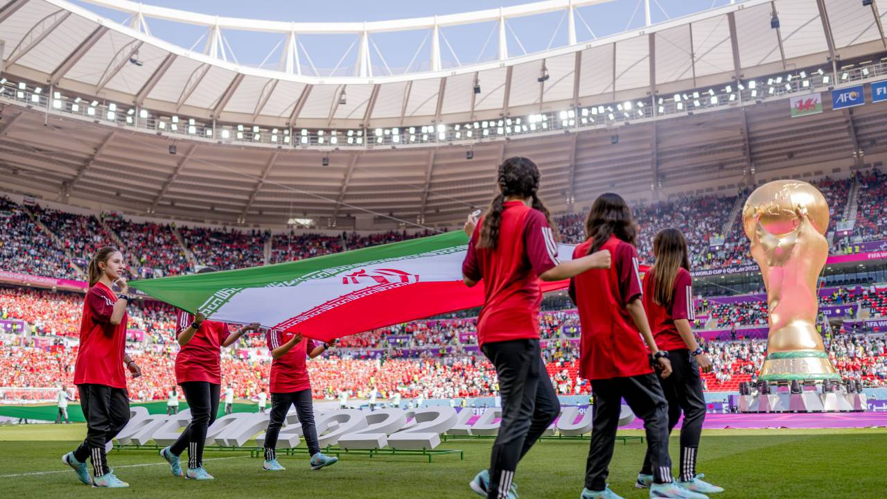 DOHA, QATAR - 25 DE NOVEMBRO: Meninas carregam a bandeira do Irã no estádio durante a partida do Grupo B da Copa do Mundo da FIFA Qatar 2022 entre País de Gales e Irã no Estádio Ahmad Bin Ali em 25 de novembro de 2022 em Doha, Qatar