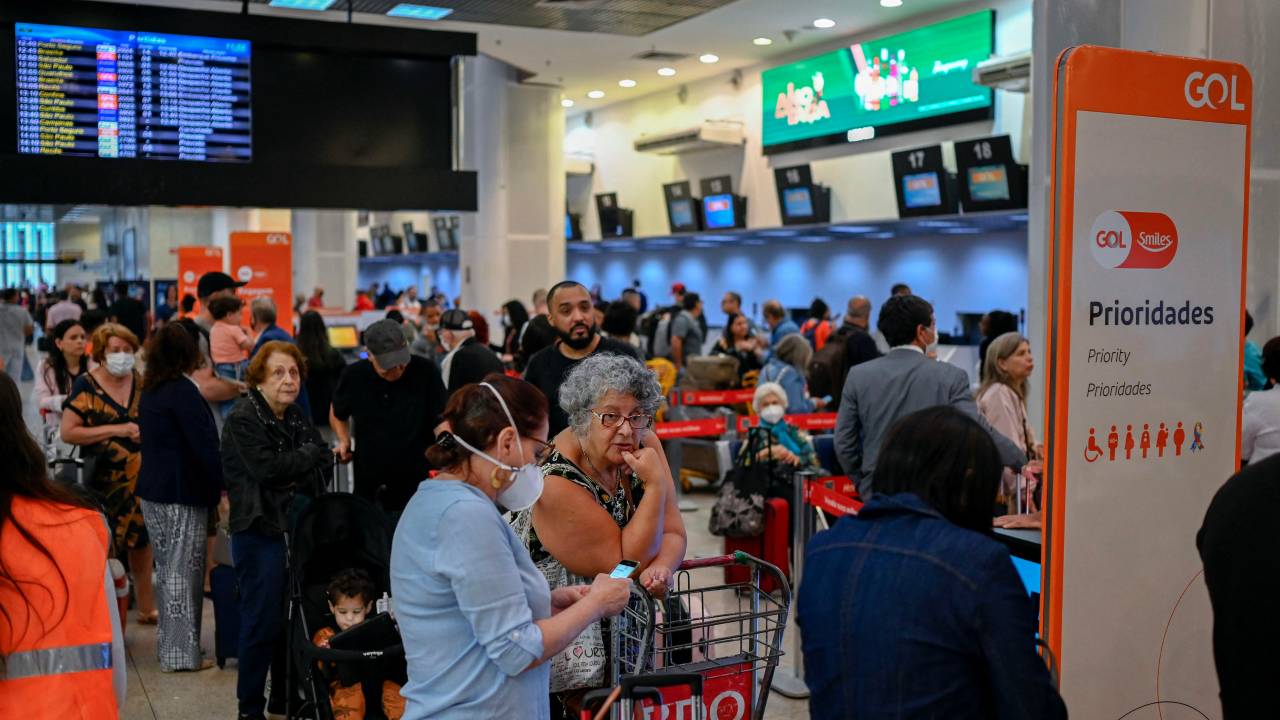 Passangers queue to do their check-in at the boarding area of the Santos Dumont Ariport in Rio de Janeiro, Brazil on December 20, 2022. - A pilot strike is taking place around several Brazilian airports prior the end of the year festivities demanding better salaries and work conditions. (Photo by MAURO PIMENTEL / AFP)