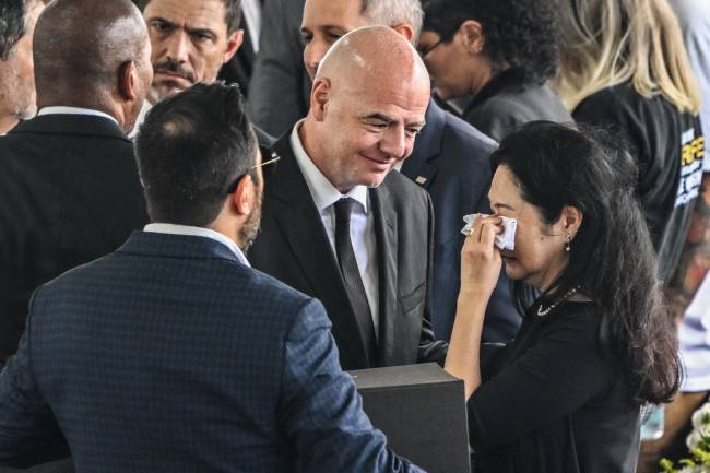 FBL-BRAZIL-PELE-DEATH-WAKE FIFA President Gianni Infantino (C) greets the wife of Brazilian football legend Pele, Marcia Aoki (R), during his wake at the Urbano Caldeira stadium in Santos, Sao Paulo, Brazil on January 2, 2023. - Brazilians bid a final farewell this week to football giant Pele, starting Monday with a 24-hour public wake at the stadium of his long-time team, Santos. (Photo by NELSON ALMEIDA / AFP)