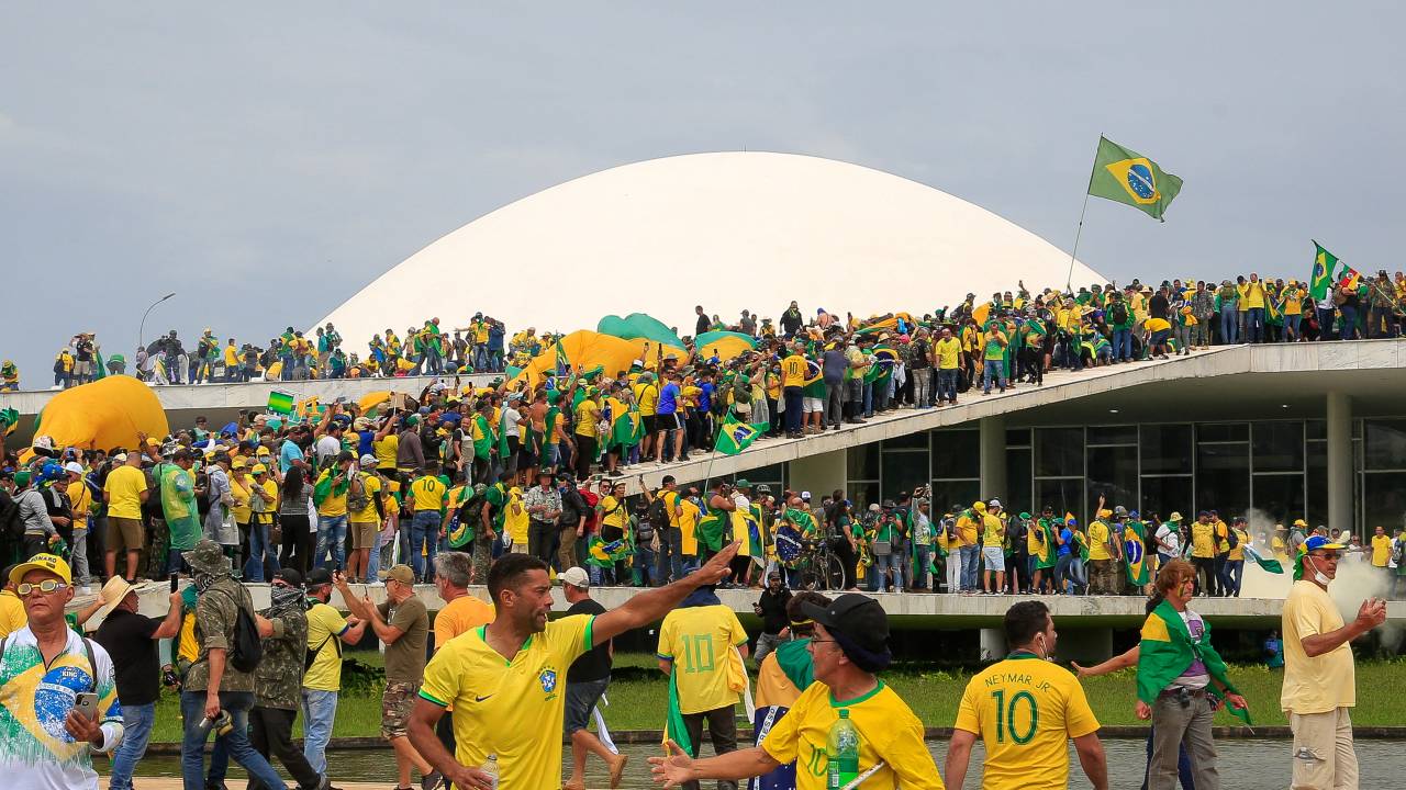 Supporters of Brazilian former President Jair Bolsonaro invade the National Congress in Brasilia on January 8, 2023. - Hundreds of supporters of Brazil's far-right ex-president Jair Bolsonaro broke through police barricades and stormed into Congress, the presidential palace and the Supreme Court Sunday, in a dramatic protest against President Luiz Inacio Lula da Silva's inauguration last week. (Photo by Sergio Lima / AFP)