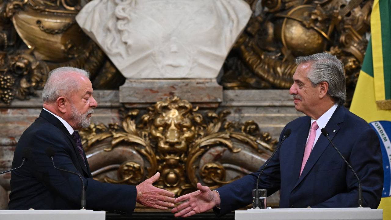 Brazilian President Luiz Inacio Lula da Silva (L) and Argentine President Alberto Fernandez (R) shake hands during a press conference at the Casa Rosada presidential palace in Buenos Aires on January 23, 2023. - Brazil's President Luiz Inacio Lula da Silva began his first international tour last Sunday with a visit to Argentina and Uruguay with the aim of restoring regional leadership to Brazil after the management of the far-right Jair Bolsonaro. (Photo by Luis ROBAYO / AFP)