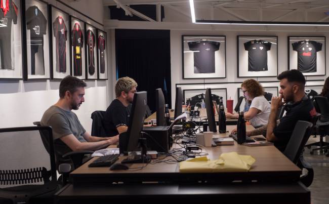 Funcionários da PaiN Gaming, com as camisas de cada temporada ao fundo Funcionários da paiN Gaming, com as camisas de cada temporada ao fundo