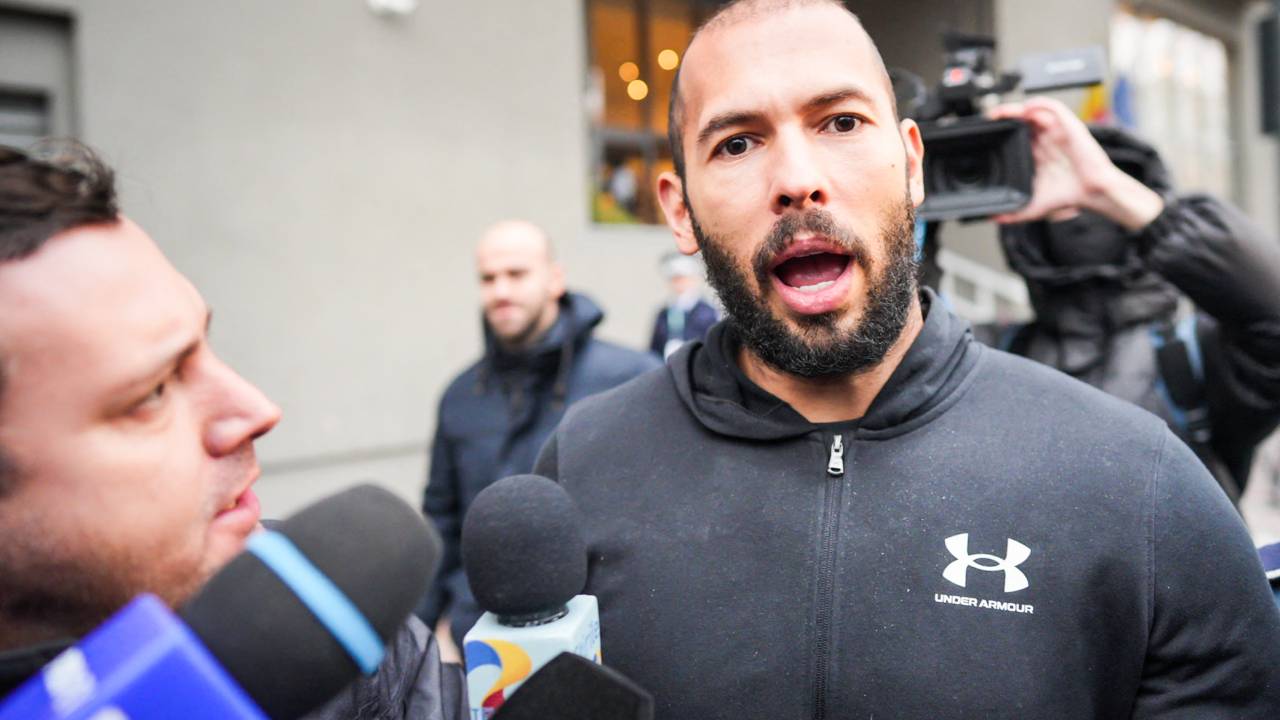 British-US former professional kickboxer and controversial influencer Andrew Tate talks to media as he leaves Romania's anti-organized crime and terrorism directorate (DIICOT), after a digital investigation of devices, where his presence was required, in Bucharest, Romania on January 25, 2023. (Photo by MIHAI BARBU / AFP)