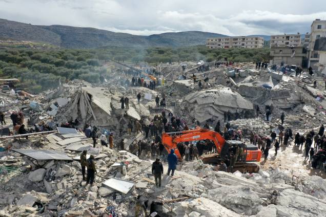 Esta vista aérea mostra residentes em busca de vítimas e sobreviventes em meio aos escombros de prédios desabados após um terremoto na vila de Besnia, perto de Harim, na Síria - Esta vista aérea mostra residentes em busca de vítimas e sobreviventes em meio aos escombros de prédios desabados após um terremoto na vila de Besnia, perto de Harim, na Síria -