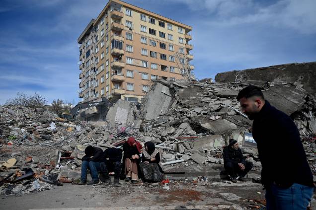 Famílias esperam entre os escombros de edifícios em Kahramanmaras, o epicentro do terremoto - Famílias esperam entre os escombros de edifícios em Kahramanmaras, o epicentro do terremoto -
