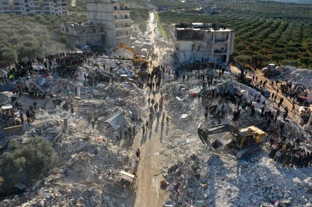 Uma foto aérea mostra equipes de resgate vasculhando os escombros de edifícios em busca de vítimas e sobreviventes na vila de Besnaya, na província de Idlib, no noroeste da Síria - Uma foto aérea mostra equipes de resgate vasculhando os escombros de edifícios em busca de vítimas e sobreviventes na vila de Besnaya, na província de Idlib, no noroeste da Síria -