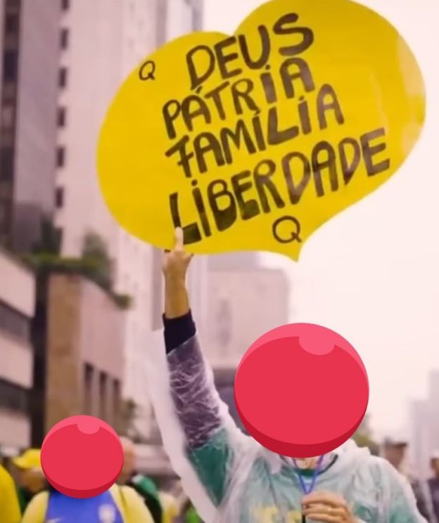 q bolso Frame da propaganda eleitoral de Bolsonaro, em 2022, filmada durante os atos de 7 de Setembro, em que manifestante segura cartaz com referências ao QAnon --
