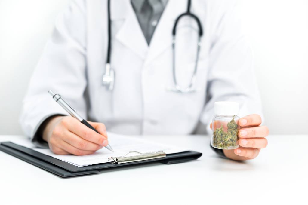 Doctor prescribes CBD for pain relief and healing. Doc holds medical marijuana in hand, offers medical cannabis, legal light medication, alternative remedies or medicines, medicine concept to patient