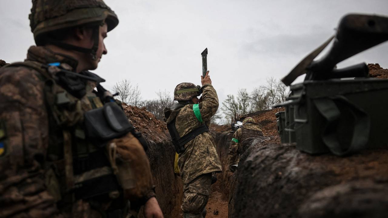 A Ukrainian infantryman of the 57th Separate Motorized Infantry Brigade "Otaman Kost Khordienko" uses a periscop to observe an enemy positions from a trench at an undisclosed location near the town of Bakhmut, Donetsk region, eastern Ukraine on April 13, 2023, amid the Russian invasion of Ukraine. (Photo by ANATOLII STEPANOV / AFP)