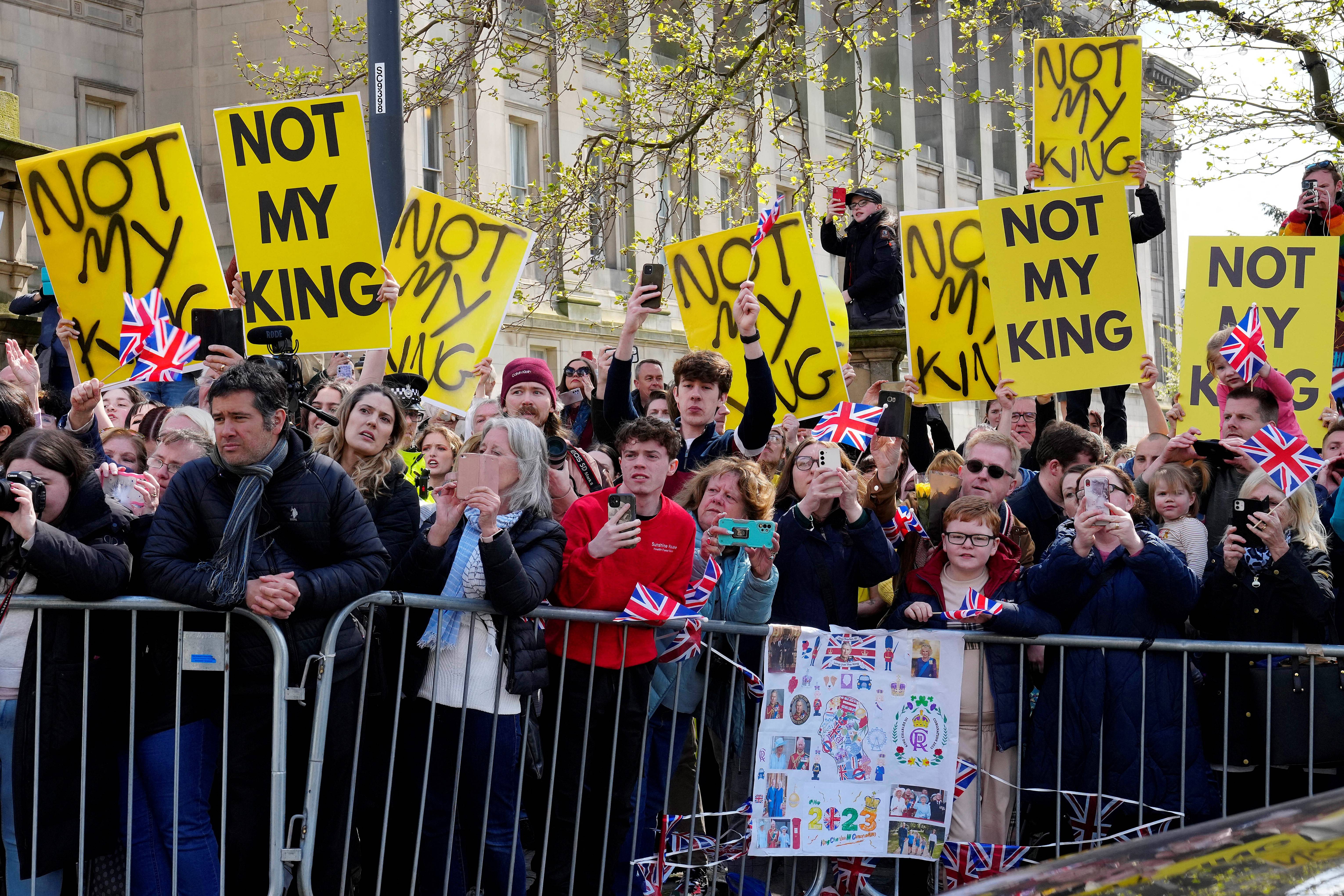 Protesters hold signs reading "Not My King" ahead of the arrival of Britain's King Charles III and Britain's Queen Consort Camilla for a visit to the Liverpool Central Library on April 26, 2023 to officially mark the Library's twinning with Ukraine's first public Library, the Regional Scientific Library in Odessa. (Photo by Jon Super / POOL / AFP)