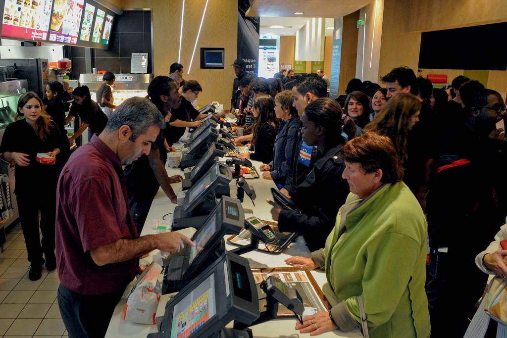Customers place orders at a McDonald’s restaurant in Paris, EXAGERO - Rede de lanchonetes em Paris: os jovens, como em todo o mundo, se rendem às porções extras