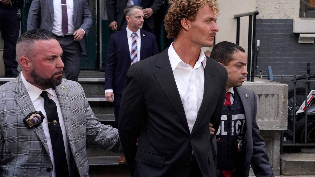 US Marine veteran Daniel Penny (C) is walked out of the New York Police Department 5th Precinct in Lower Manhattan, May 12, 2023 on his way to a arraignment after he surrendered to authorities after being charged with 2nd Degree Manslaughter in the chokehold death of Jordan Neely. The death of Jordan Neely -- widely identified as a Michael Jackson impersonator who often performed on the train -- earlier this month sparked outrage. (Photo by TIMOTHY A. CLARY / AFP)