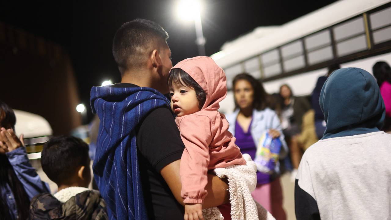 YUMA, ARIZONA - MAY 11: A Peruvian immigrant father holds his daughter (C), both of whom are seeking asylum in the United States with other family members, as they wait to board a bus during processing by U.S. Border Patrol agents in the early morning hours after crossing into Arizona from Mexico on May 11, 2023 in Yuma, Arizona. A surge of immigrants is expected with today's end of the U.S. government's Covid-era Title 42 policy, which for the past three years has allowed for the quick expulsion of irregular migrants entering the country. Over 29,000 immigrants are currently in the custody of U.S. Customs and Border Protection ahead of the sunset of the policy later today. Mario Tama/Getty Images/AFP (Photo by MARIO TAMA / GETTY IMAGES NORTH AMERICA / Getty Images via AFP)