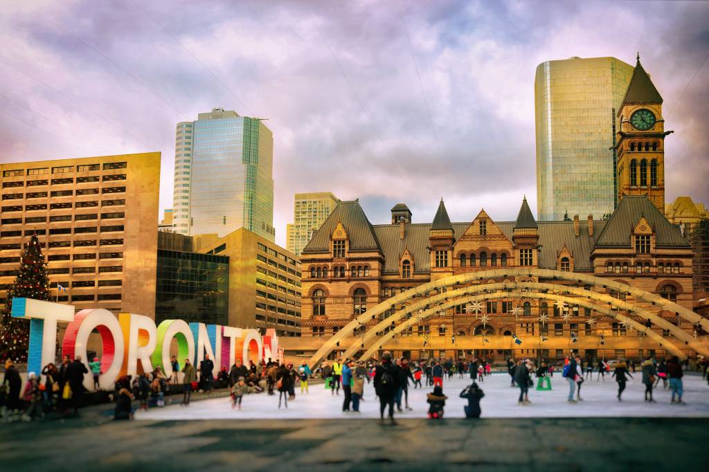 Lots of people are having fun by the colourful Toronto sign at Nathan Phillips Square.