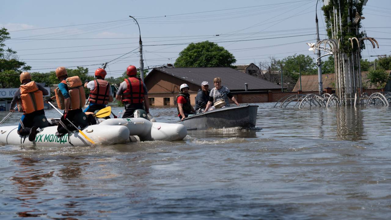 Ukrainian security forces transport local residents in a boat during an evacuation from a flooded area in Kherson on June 7, 2023, following the destruction of Kakhovka hydroelectric power plant dam. More than 2,700 people have been evacuated on both sides of the Dnipro River from flooding caused by the destruction of the Russian-occupied Kakhovka dam in Ukraine, officials said June 7, 2023. (Photo by ALEKSEY FILIPPOV / AFP)