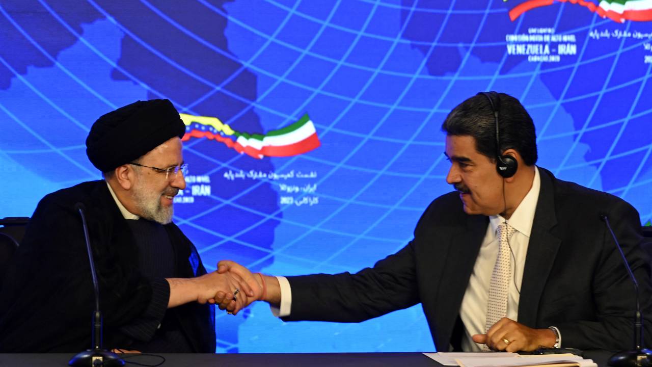 Iranian President Ebrahim Raisi (L) and Venezuelan President Nicolas Maduro shake hands during a joint press statement at Miraflores Presidential Palace in Caracas, on June 12, 2023. Iranian President Ebrahim Raisi arrived in Venezuela Monday for the start of a visit to "friendly countries" that also include Cuba and Nicaragua, all under sanctions from a common adversary, the United States. (Photo by YURI CORTEZ / AFP)