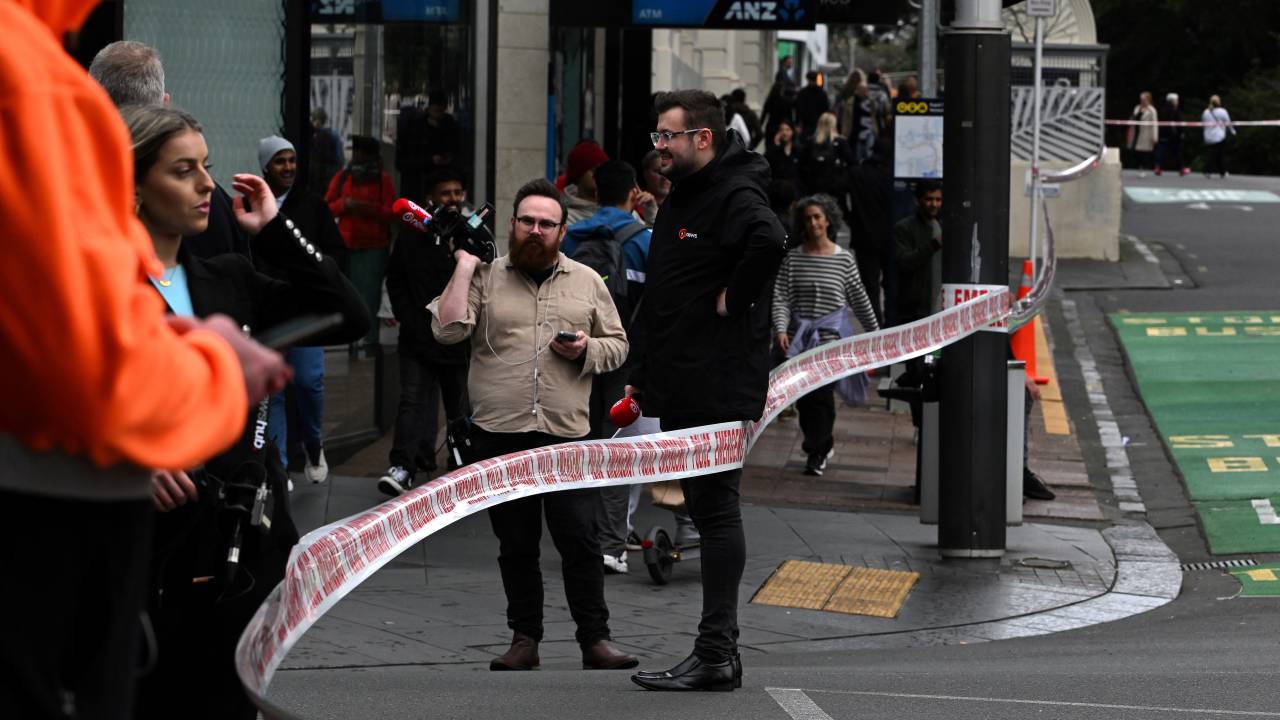 Media gather near the site of a shooting in central Auckland on July 20, 2023. New Zealand Prime Minister Chris Hipkins said a shooting that killed two people in central Auckland hours before the women's football World Cup opener July 20, 2023 was not linked to a national security threat and the tournament will go ahead as planned. (Photo by Saeed KHAN / AFP)