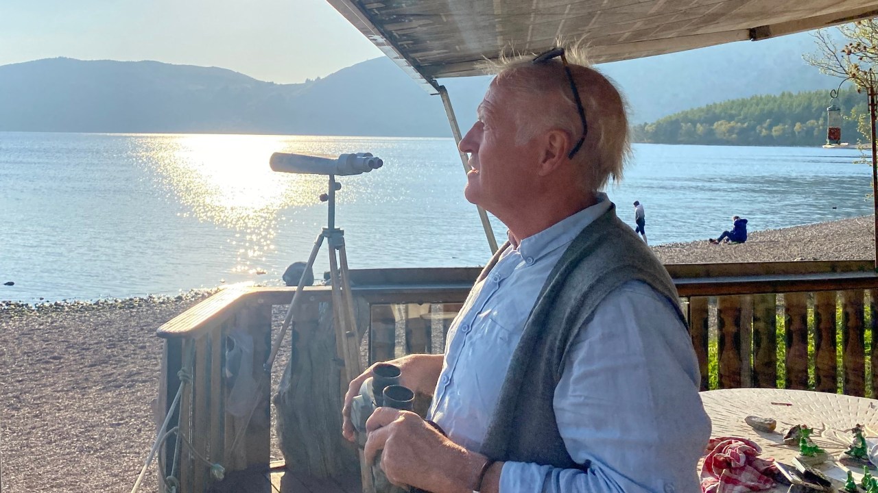 PRODUCTION - 21 April 2023, Great Britain, Dores: "Nessie hunter" Steve Feltham looks at Loch Ness. For decades, Steve Feltham has been observing the legendary lake in the Scottish Highlands. It is obvious who plays the leading role around Loch Ness: the legend of the lake monster has fired people's imagination for decades. But is Nessie really in the famous lake? (to dpa "Really a monster? Loch Ness does not reveal its mystery") Photo: Benedikt von Imhoff/dpa (Photo by Benedikt von Imhoff/picture alliance via Getty Images)