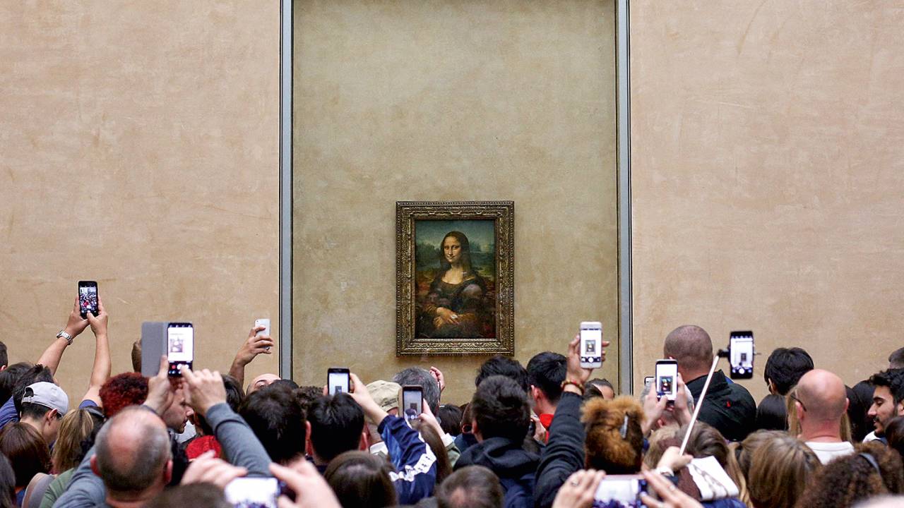 SORRISO MAGNÉTICO - Turistas se acotovelam para ver a Mona Lisa: alguém percebe o sfumato no fundo da tela?
