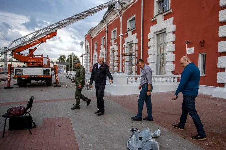 Roman Starovoit, governador da região de Kursk (segundo a partir da direita), e outras autoridades inspecionam o local de um ataque de drone ucraniano em Kursk, Rússia. 20/08/2023 -