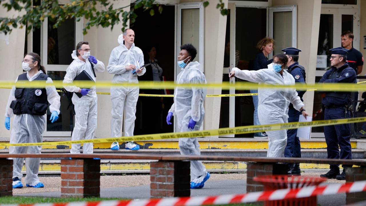 French police officers from the forensic service stand in front of the Gambetta high school in Arras, northeastern France on October 13, 2023, after a teacher was killed and two other people severely wounded in a knife attack, police and regional officials said. The perpetrator has been detained by police, Interior Minister Gerald Darmanin wrote on X, formerly Twitter. (Photo by Ludovic MARIN / POOL / AFP)