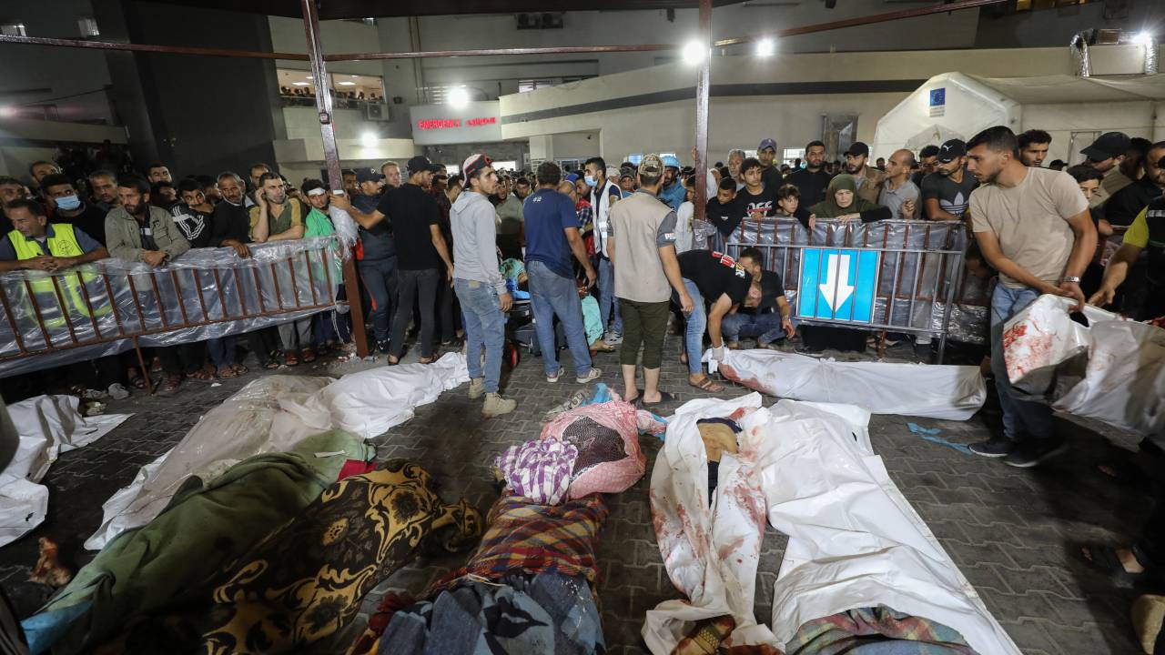 EDITORS NOTE: Graphic content / People gather around bodies of Palestinians killed in Israeli airstrikes on the Ahli Arab hospital in central Gaza after they were transported to Al-Shifa hopsital, on October 17, 2023. Israeli air strikes on a Gaza hospital compound on October 17 killed at least 200 people, the health ministry in the Hamas-run Palestinian territory said, while an Israeli military spokesman would not immediately confirm its forces bombed the hospital. (Photo by Dawood NEMER / AFP)