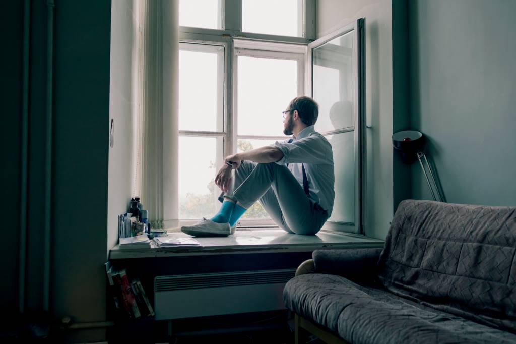 Man sitting on window sill Man sitting on window sill