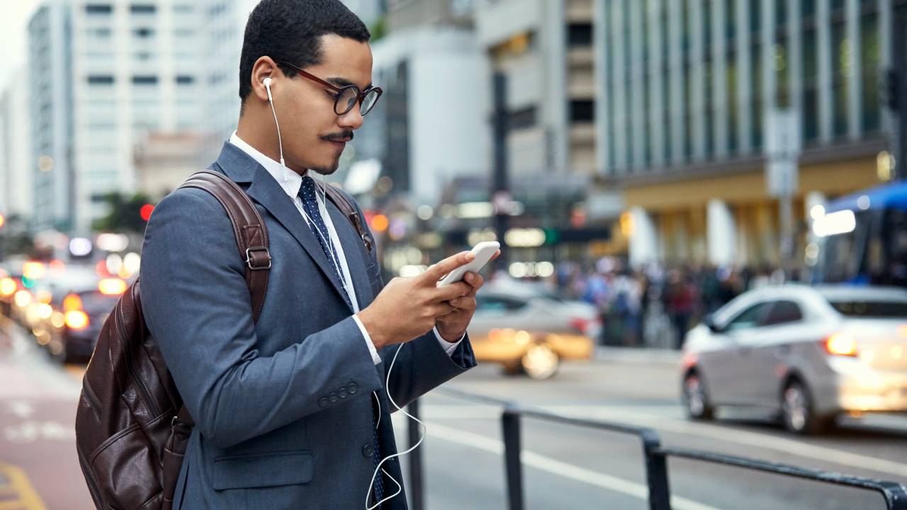 Businessman surfing net on smart phone in city