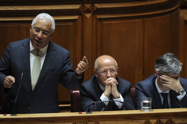 Portuguese Prime Minister Antonio Costa Speaks At The State Of The Nation Debate Antonio Costa, Portugal's prime minister, left, speaks as Augusto Santos Silva, Portugal's foreign minister, center, and Mario Centeno, Portugal's finance minister, listen during the state-of-the-nation debate at parliament in Lisbon, Portugal, on Thursday, July 7, 2016. Spain and Portugal were hit by a European Union move to fine them for breaching budget deficit limits in an unprecedented step to enforce rules designed to avert another debt crisis. Photographer: Paulo Duarte/Bloomberg via Getty Images