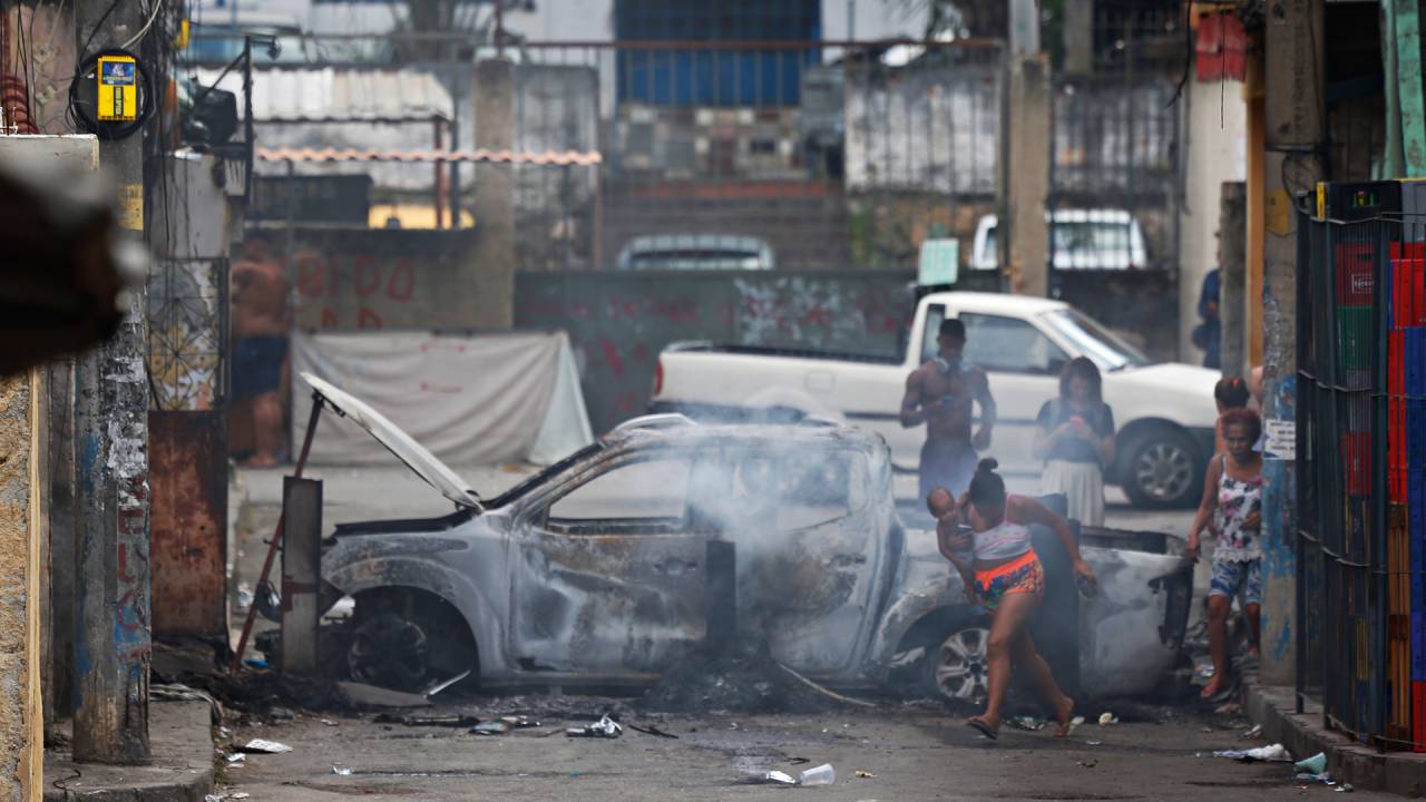 GUERRA - Carro queimado no Complexo do Alemão: polícia combate expansão de território do crime