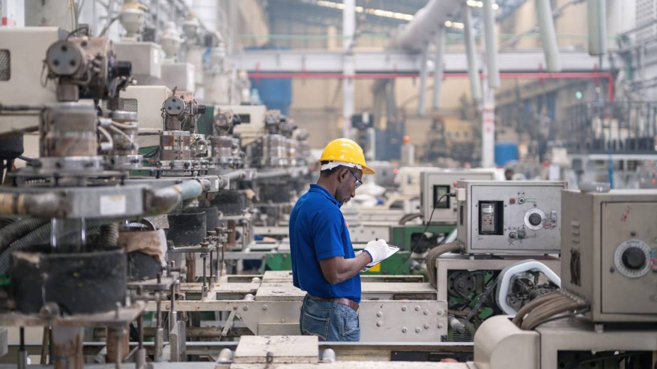 Homem trabalhando na linha de produção de máquina de sacola plástica