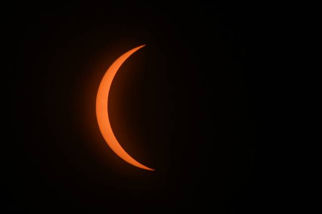 The moon begins to eclipse the sun during the total solar eclipse in Mazatlan, Sinaloa state, Mexico on April 8, 2024. This year's path of totality is 115 miles (185 kilometers) wide and home to nearly 32 million Americans, with an additional 150 million living less than 200 miles from the strip. The next total solar eclipse that can be seen from a large part of North America won't come around until 2044. (Photo by MARIO VAZQUEZ / AFP)