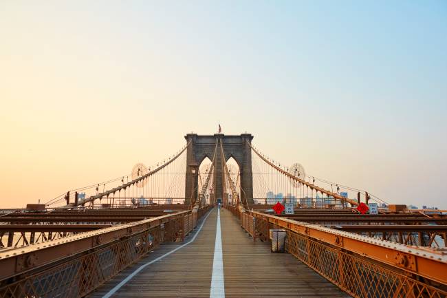 Brooklyn Bridge at sunrise. Junto ao Empire State e à Estátua da Liberdade, a Brooklyn Bridge é um dos principais cartões-postais de Nova York