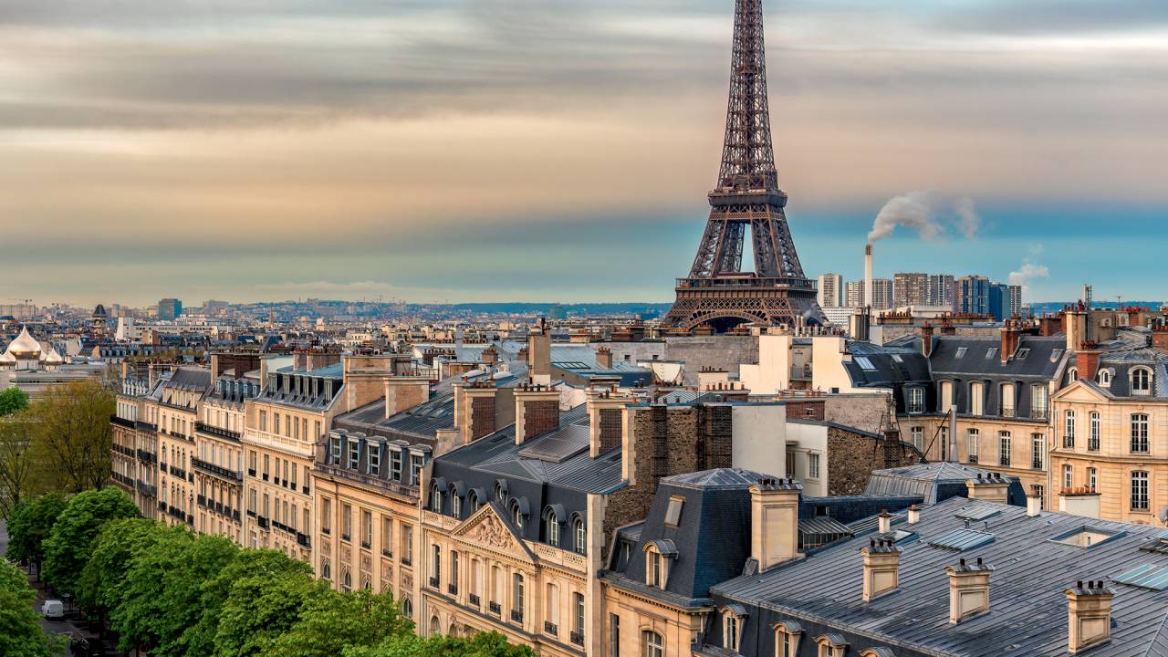 Eifel Tower against colorful sky and old town building in Paris, France.
