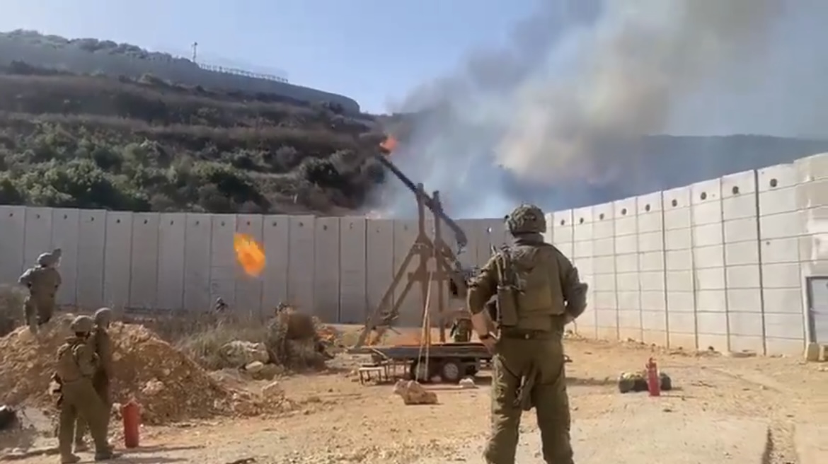 Forças israelenses utilizando um trabuco para lançar bolas de fogo ao território libanês.