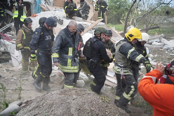 Trabalhadores em operação de busca e resgate após bombardeio russo atingir a região de Kharkiv. 10/06/2024