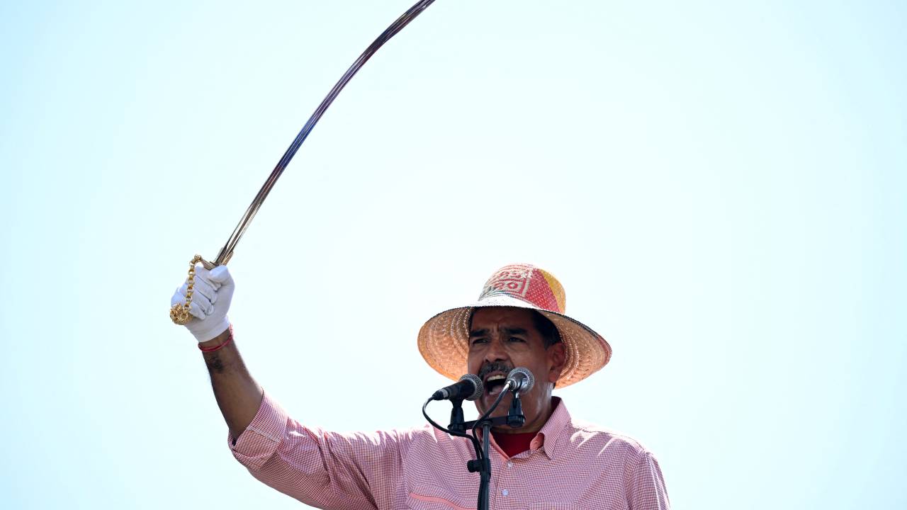 Venezuelan President and presidential candidate Nicolas Maduro raises a replica of Liberator Simon Bolivar's sword as he speaks during his campaign closing rally in Maracaibo, Zulia State, Venezuela, on July 25, 2024, ahead of Sunday's presidential election. Venezuelan President Nicolas Maduro and his main rival in the July 28 presidential elections, opposition candidate Edmundo Gonzalez Urrutia, close their campaigns on Thursday amidst Maduro's warnings of a "bloodbath" or a military insurrection if he is defeated. (Photo by Raul ARBOLEDA / AFP)
