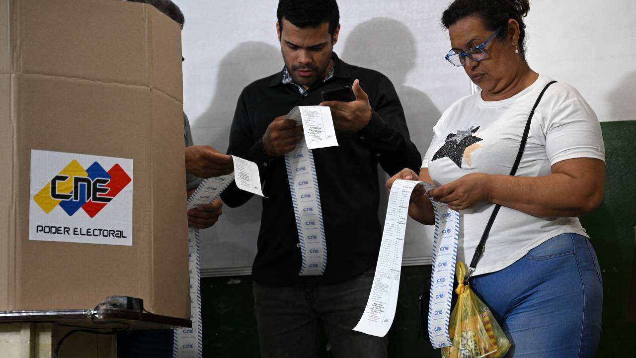 Election staffers count votes after polling stations closed during the presidential election, in Caracas on July 28, 2024. Venezuelans vote Sunday between continuity in President Nicolas Maduro or change in rival Edmundo Gonzalez Urrutia amid high tension following the incumbent's threat of a "bloodbath" if he loses, which polls suggest is likely. (Photo by Raul ARBOLEDA / AFP)