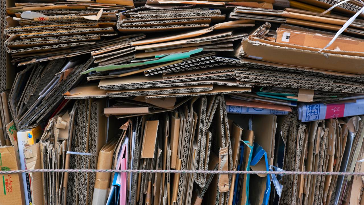 A detailed view shows neatly flattened and stacked corrugated cardboard boxes collected for recycling in the northern Kita district of Kyoto, Japan.